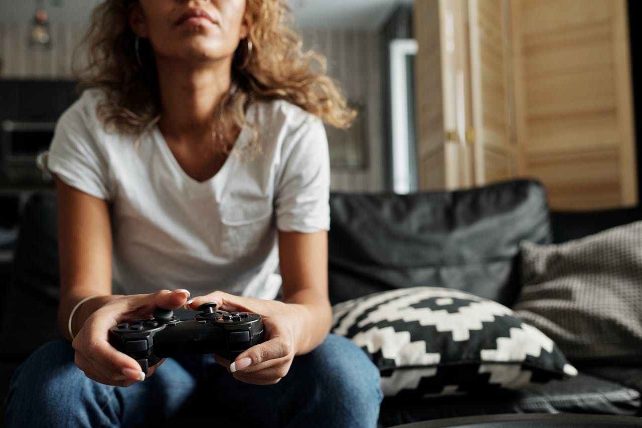 about-04 Young woman enjoying leisure time playing video games at home, holding controller.