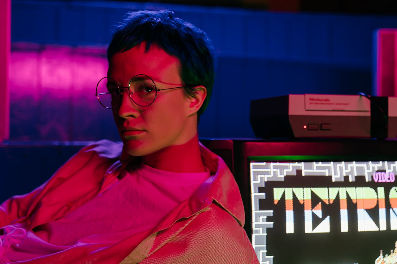 about-02 A teenager with eyeglasses in an 80s-style arcade displaying a Tetris game on screen.