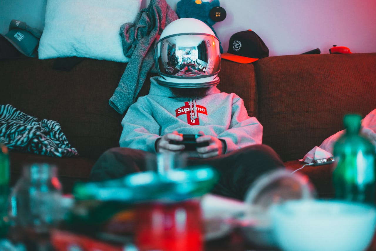 Teen wearing a VR helmet and gaming on a couch. Immersive and fun indoor activity.